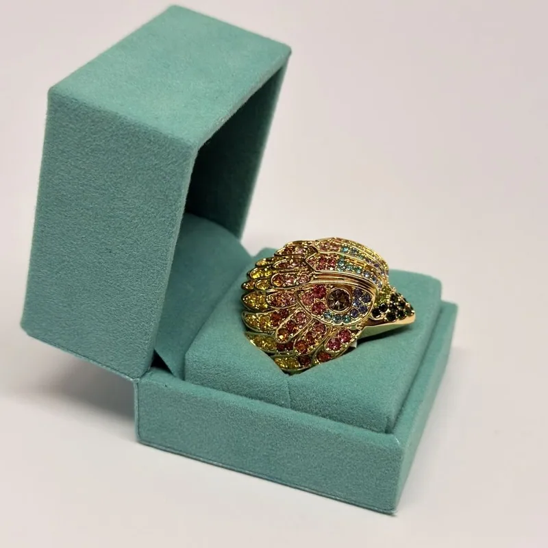 Anel dourado com cristais multicoloridos em relevo e detalhe escuro — ref. ANQ0127A