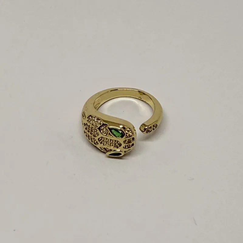 Anel dourado em formato de serpente com olhos verdes e cravação — ref. ANQ0065A