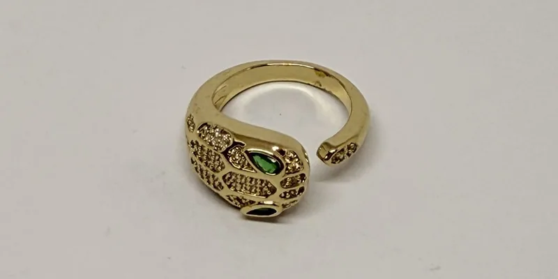 Anel dourado em formato de serpente com olhos verdes e cravação — ref. ANL0045A