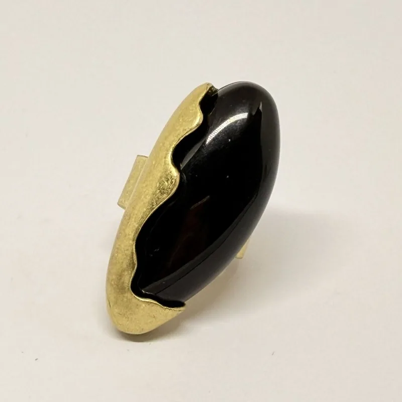 Anel dourado com pedra preta alongada em moldura ondulada — ref. ANQ0077A