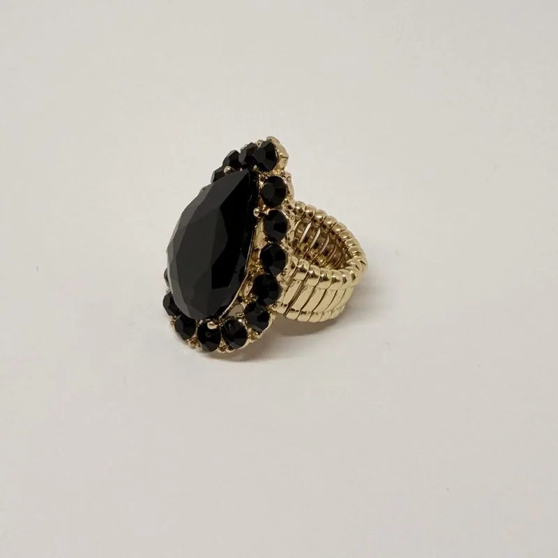 Anel dourado com pedra preta em formato de gota e contorno de cristais escuros — ref. ANQ0071A
