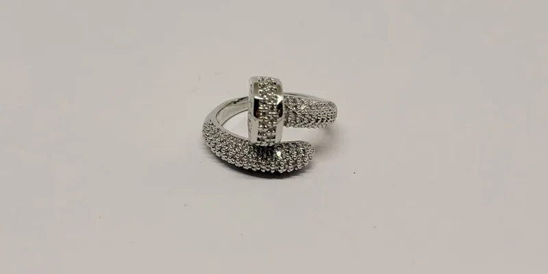 Anel prateado com aros cruzados cravejados e detalhe geométrico — ref. ANL0037A