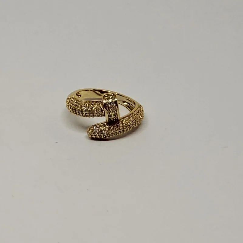 Anel dourado com aros cruzados e faixa cravejada — ref. ANQ0017A