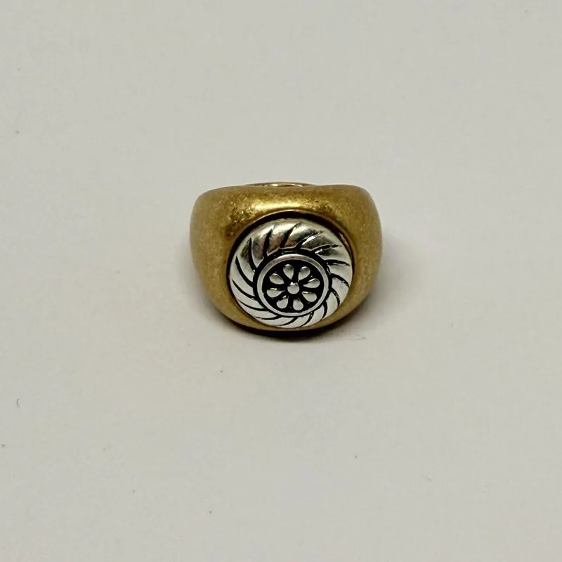 Anel dourado tipo sinete com medalhão prateado e desenho de roseta