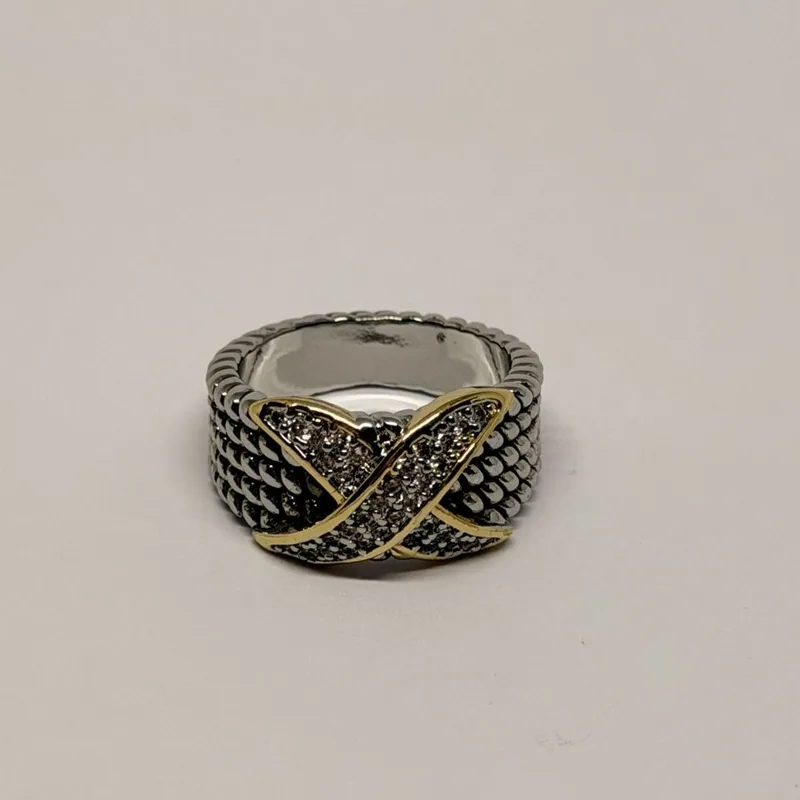 Anel prateado de aro largo com textura em escamas e faixa dourada em X cravejada — ref. ANQ0147A