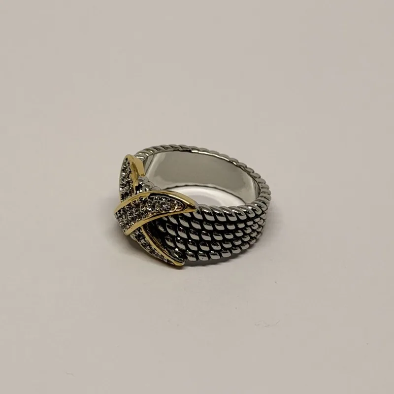 Anel prateado de aro largo com textura em escamas e faixa em X cravejada de cristais — ref. ANQ0148A
