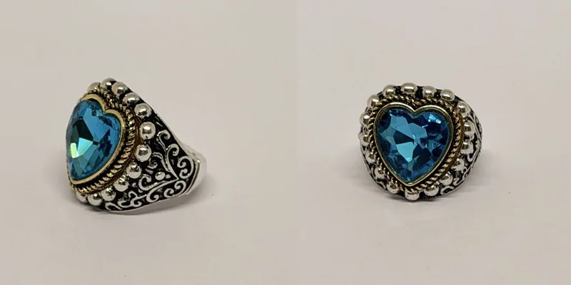 Anel prateado com cristal azul em coração, moldura dourada e arabescos — ref. ANL0098A