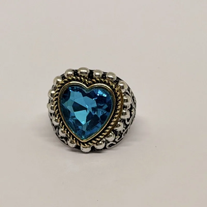Anel prateado com cristal azul em formato de coração e moldura dourada — ref. ANQ0168A