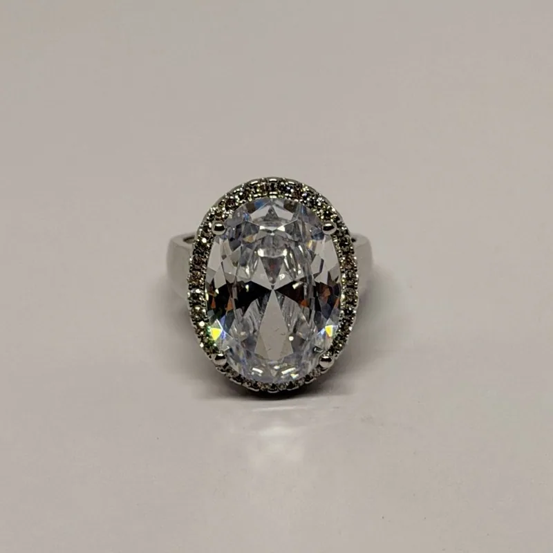 Anel prateado com cristal oval grande e contorno cravejado — ref. ANQ0123A