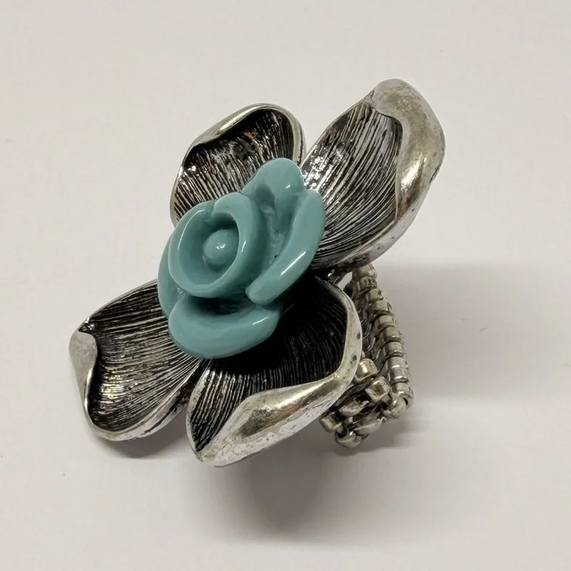Anel prateado em flor de pétalas texturizadas com rosa azul em resina e aro elástico — ref. ANQ0094A