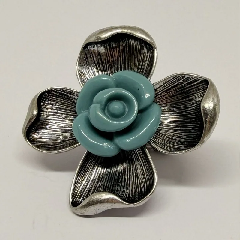 Anel prateado em formato de flor de quatro pétalas texturizadas com rosa em resina azul ao centro — ref. ANQ0093A