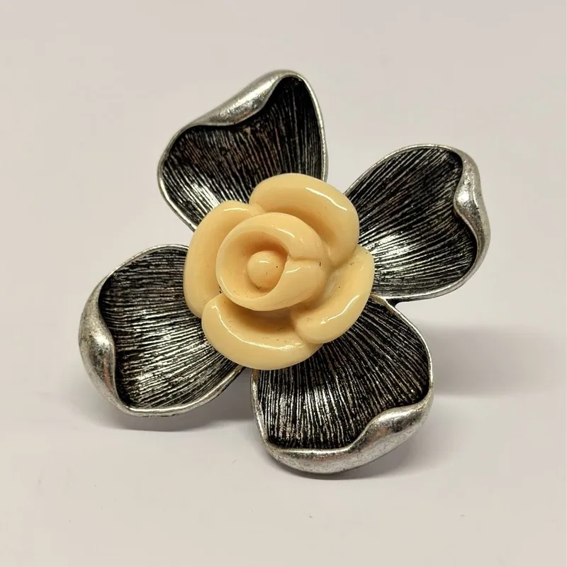Anel prateado em formato de flor de quatro pétalas texturizadas com rosa em resina bege ao centro — ref. ANQ0091A