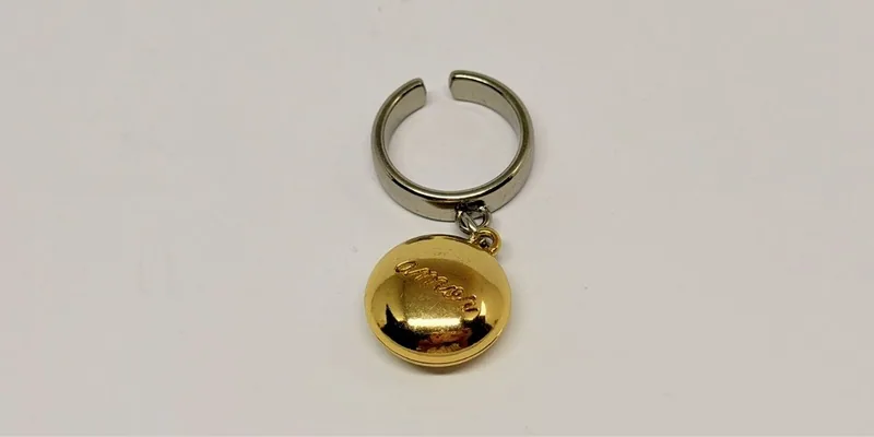 Anel prateado aberto com meia-esfera dourada pendente — ref. ANL0042A