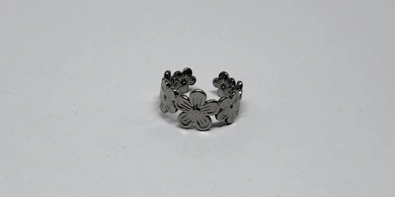 Anel prateado aberto com flores em relevo ao redor do aro — ref. ANL0013A