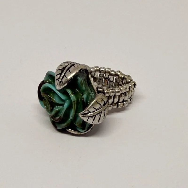 Anel prateado com rosa verde em resina, folhas em relevo e aro elástico — ref. ANQ0098A