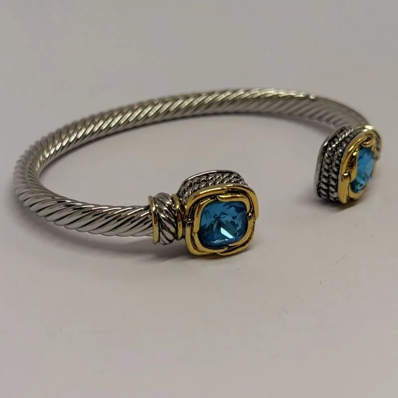 Bracelete dourado com pedra central oval e moldura ornamental — ref. BTE0056A