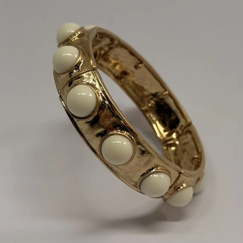 Bracelete dourado rígido com cabochões brancos distribuídos — ref. BTE0109A