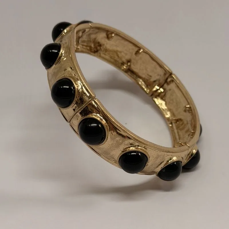 Bracelete dourado rígido com cabochões pretos distribuídos — ref. BTE0110A