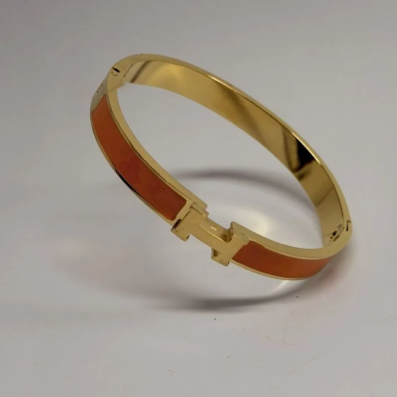 Bracelete dourado rígido e estreito com esmalte laranja na face interna — ref. BTE0111A