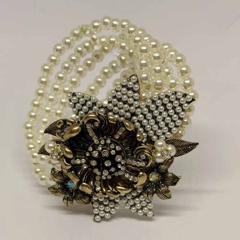 Bracelete de múltiplas fileiras de pérolas com medalhão floral dourado e cristais