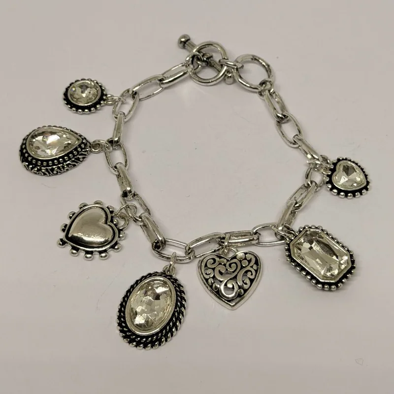 Bracelete prateado com pingentes de cristais transparentes e corações ornamentados