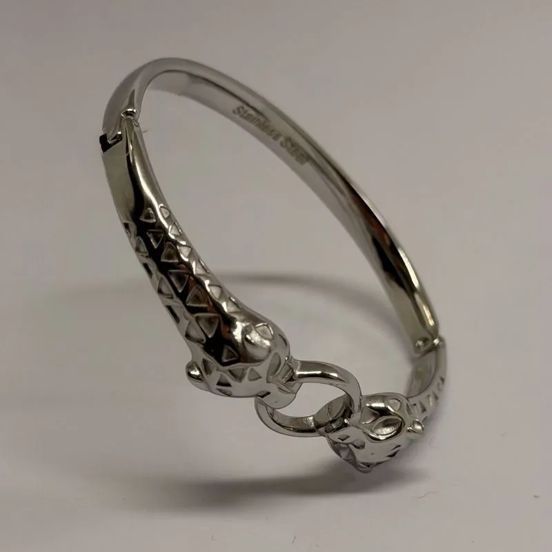 Bracelete prateado rígido com elos entrelaçados no fecho e relevo gravado — ref. BTE0112A