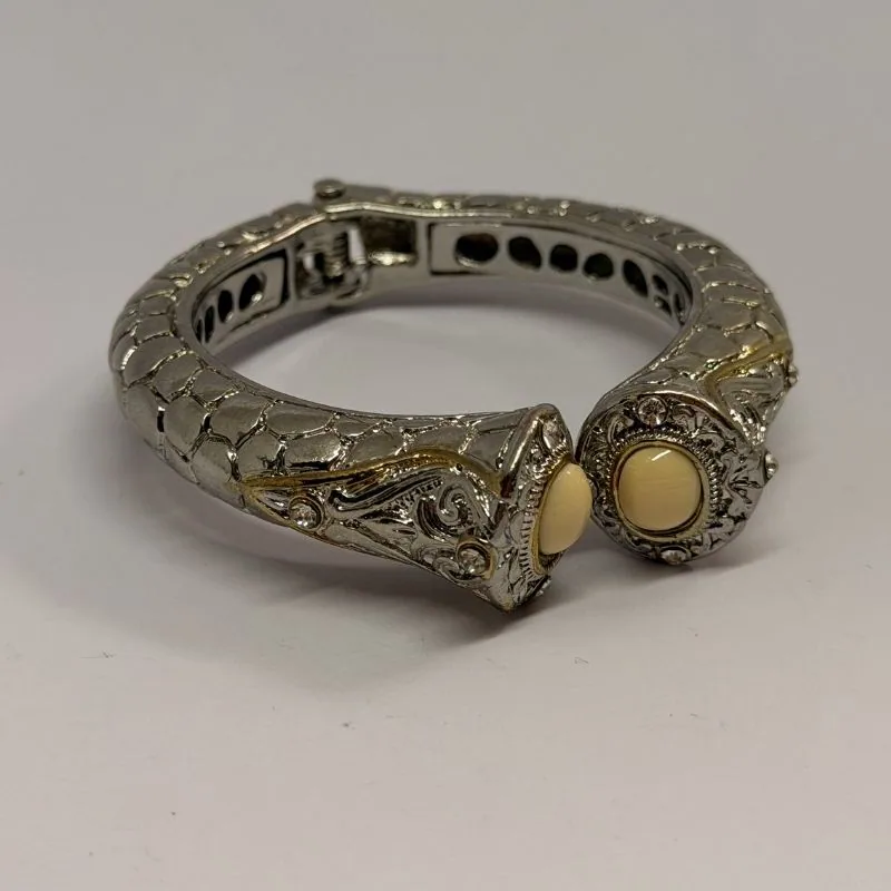 Bracelete prateado rígido com relevo em arabescos e duas pedras claras nas pontas — ref. BTE0086A