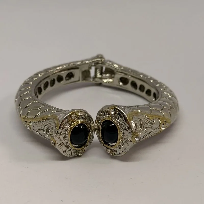 Bracelete prateado rígido com relevo em arabescos e duas pedras pretas nas pontas — ref. BTE0088A