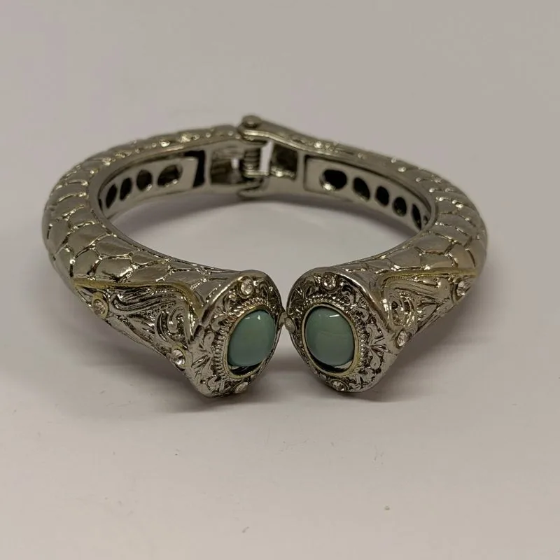 Bracelete prateado rígido com relevo em arabescos e duas pedras verdes nas pontas — ref. BTE0087A