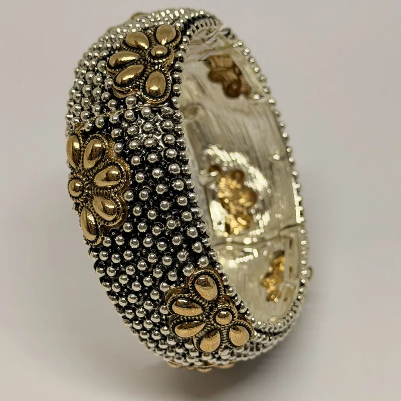 Bracelete prateado texturizado com flores douradas em relevo