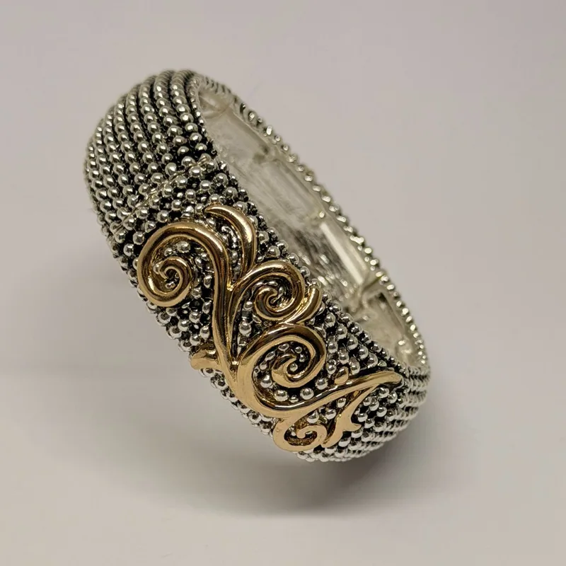 Bracelete prateado texturizado com volutas douradas em relevo