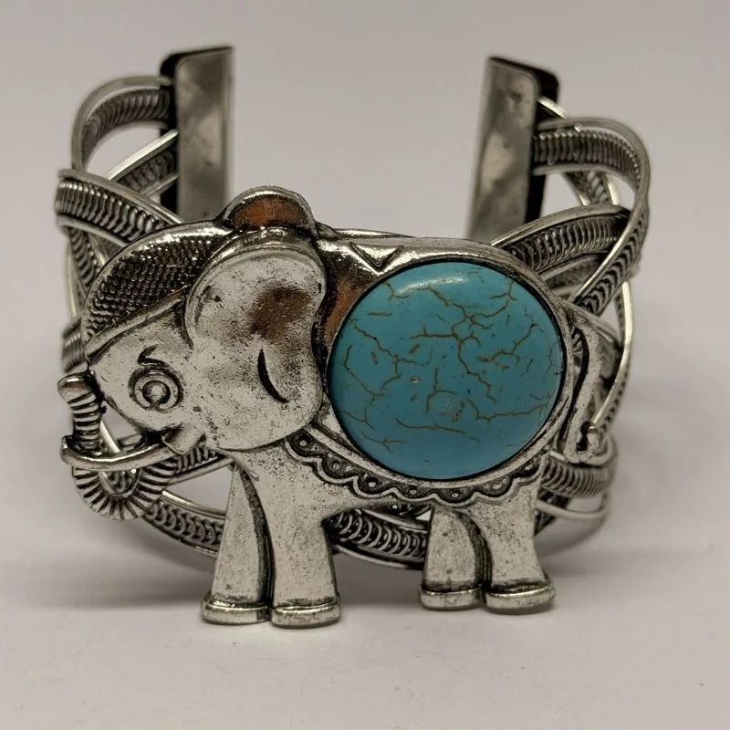 Bracelete prateado tipo cuff com elefante em relevo e pedra turquesa central — ref. BTE0116A