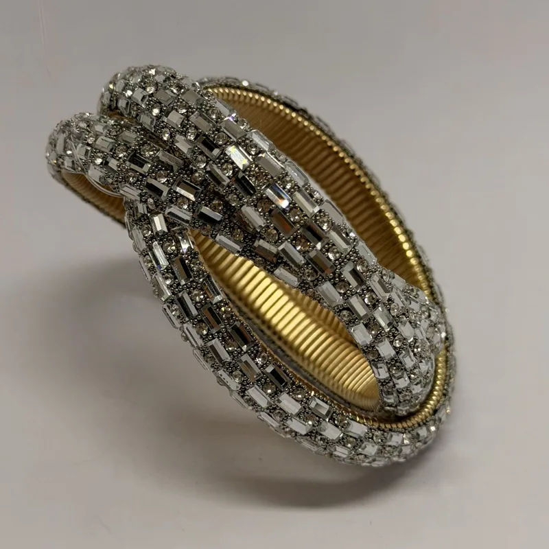 Bracelete torcido com cristais baguete sobre base dourada elástica