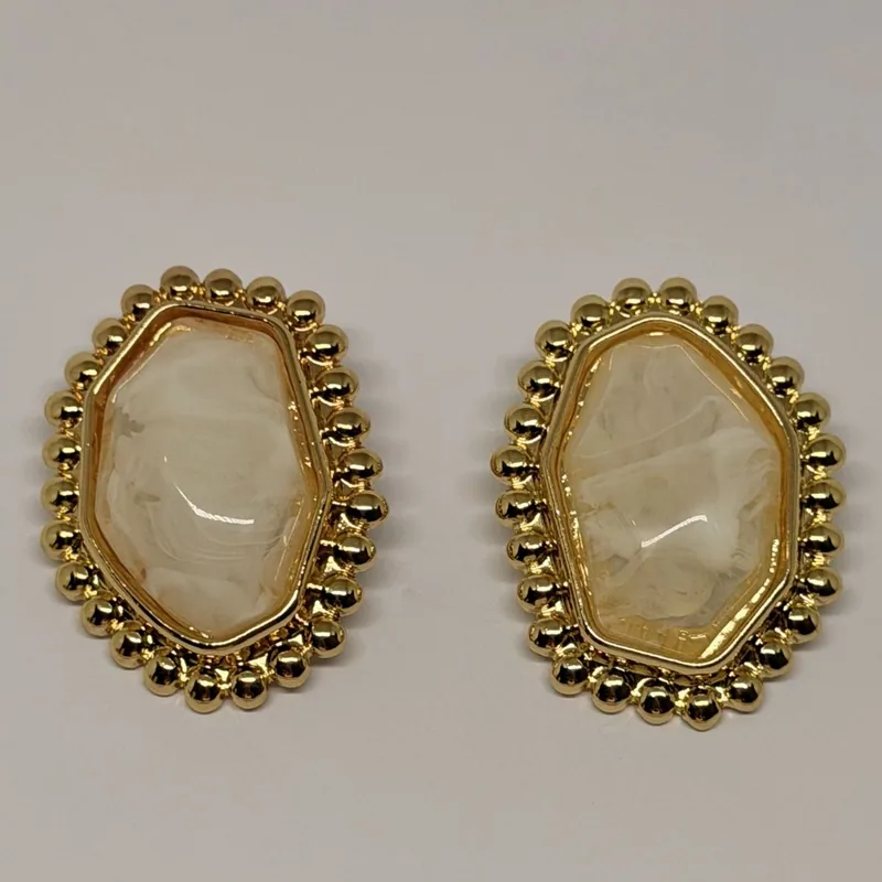 Brinco dourado oval com pedra clara marmorizada ao centro e moldura de esferas — ref. BRC0066A