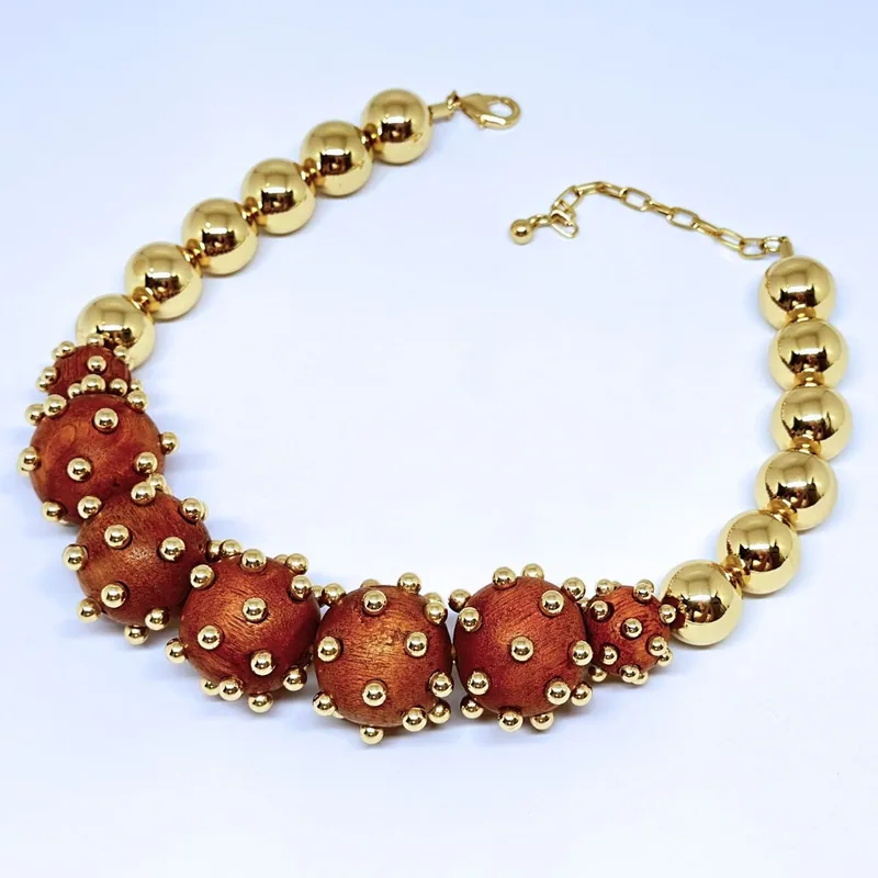 Colar dourado de esferas com trecho central em contas vermelhas e detalhes em relevo — ref. CLR0090A
